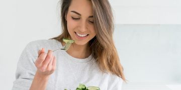 Healthy young woman dieting and eating a salad at home Healthy young woman dieting and eating a salad at home
