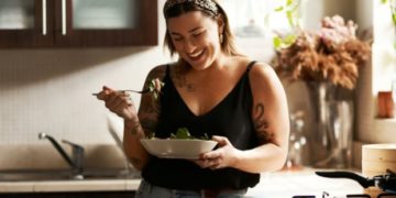 Shot of a young woman eating a healthy salad at home Shot of a young woman eating a healthy salad at home