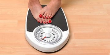 Obese woman weighing herself Obese woman weighing herself